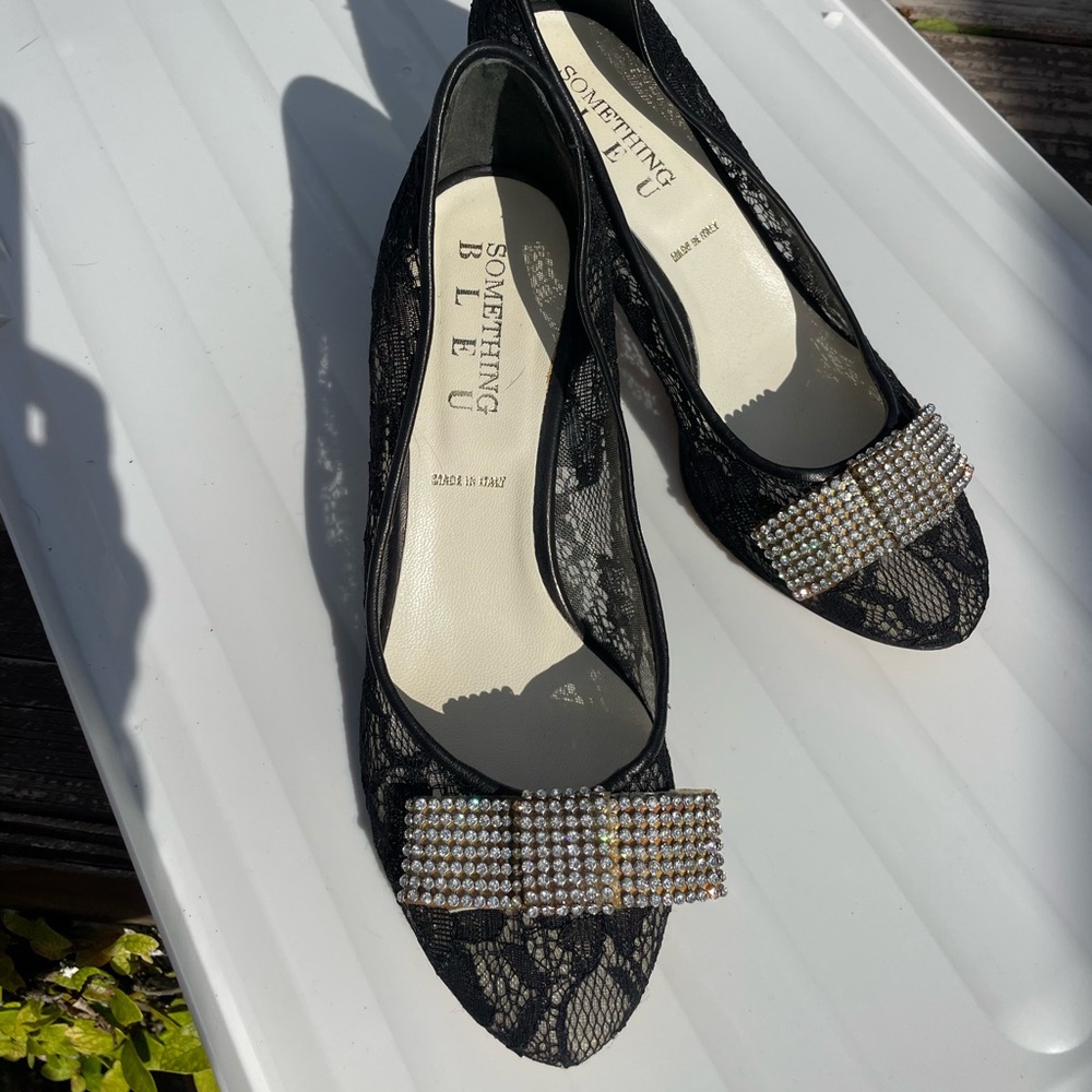 Something Bleu black lace heels with rhinestones bow on toe.